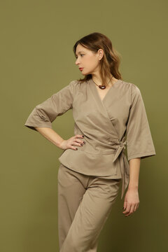 Fashion model wearing brown poplin smart casual outfit with a tie front blouse and wide leg trousers, elegant modern style