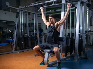 Fotobehang Sportschool Man executing a lat pulldown exercise in the gym  © Nomad_Soul