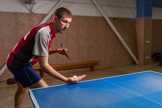 Male table tennis player preparing to serve the ball