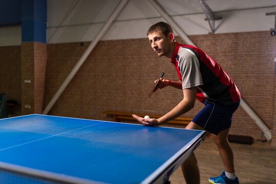 Male table tennis player preparing to serve the ball