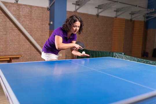 Female table tennis player preparing to serve