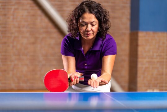 Female table tennis player preparing to serve
