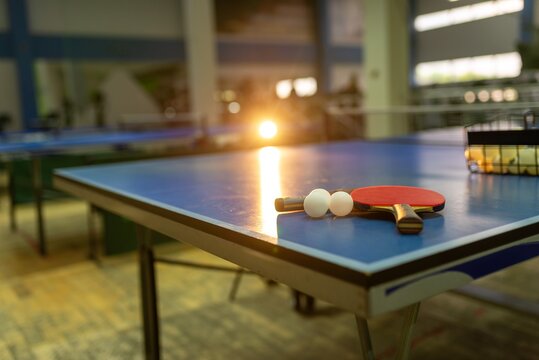 Table tennis paddles and balls on a blue tennis table