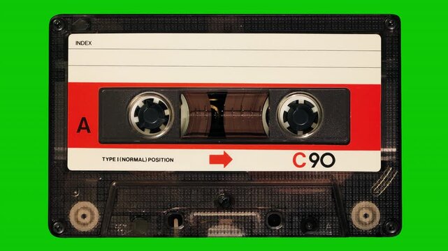 Vintage C90 audio cassette tape playing on green background with alpha channel for seamless loop playback.