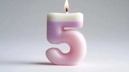 Naklejka premium Gradated Pastel Five Number Candle Isolated On A White Surface Celebrating A Child Fifth Birthday.