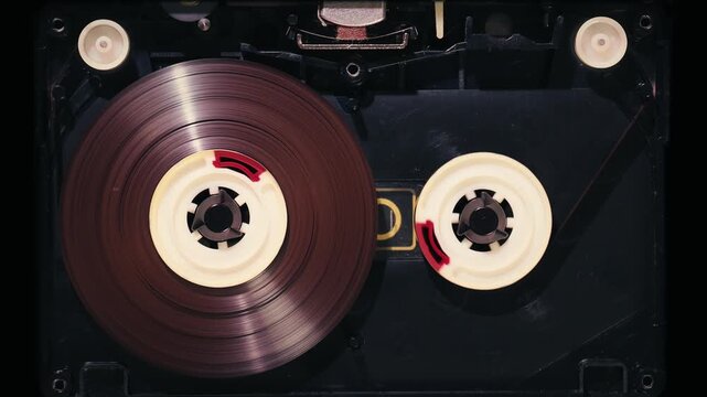 Close-up of play head engaging magnetic tape to start normal speed audio playback inside open cassette deck