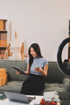 Woman recording live stream preparing packages for online selling