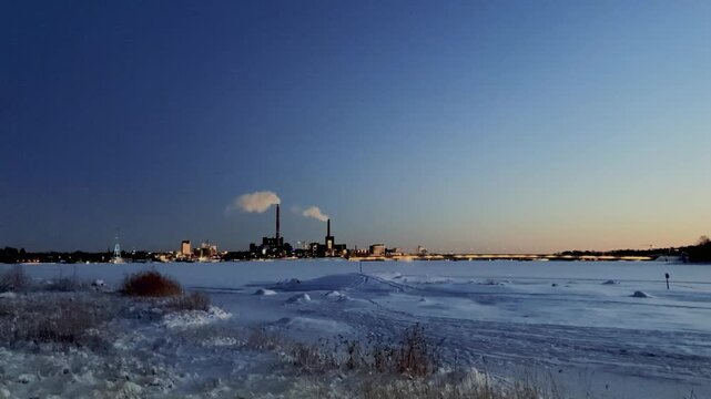Frozen Sea and Distant City Skyline in Winter Dusk