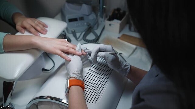 Professional cuticle separation during manicure in beauty salon using metal pusher and following cleanliness standards