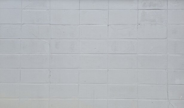 Grey concrete block wall texture background. Grid pattern of a painted grey cinder block wall with rough surface. Grey cement brick pattern texture surface.