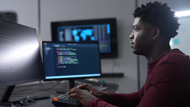 African male programmer coding on computer monitors in modern technology office, Software development, IT business startup, professional software engineer working on smart future digital innovations