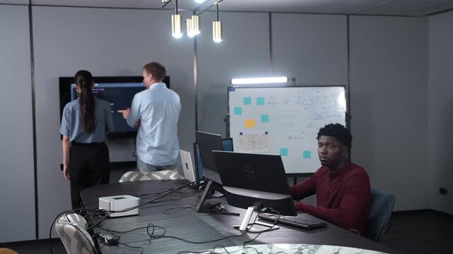 African male programmer coding on computer monitors in modern technology office, Software development, IT business startup, professional software engineer working on smart future digital innovations