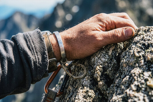Hand gripping a rocky mountain summit
