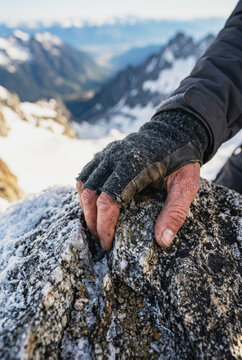 Climber hand gripping a frozen rock face