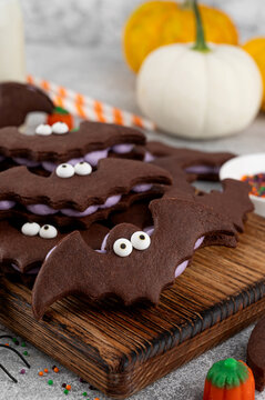 Halloween cookies. Chocolate sandwich cookies in the shape of a bat with eyes and butter cream. Funny food idea. Top view.