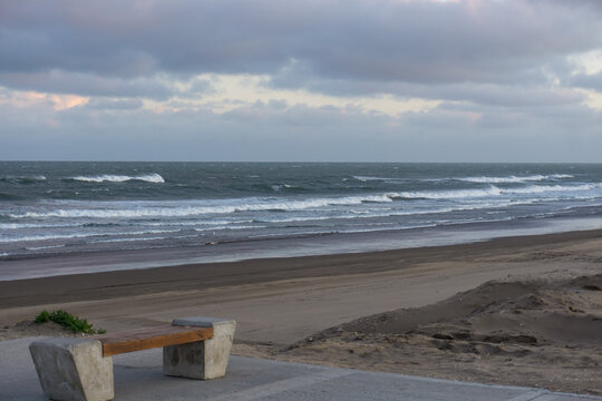 Empty Beach with Waves and Storm Clouds
