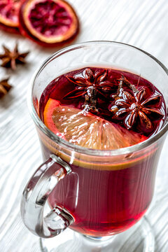 mulled wine with spices in cup on wooden background