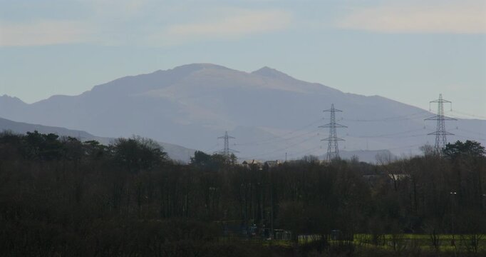 Shot of Mountains and pylons from A5, Ffordd Caergybi, Llanfairpwllgwyngyll at the Menai suspension bridge and Menai Strait