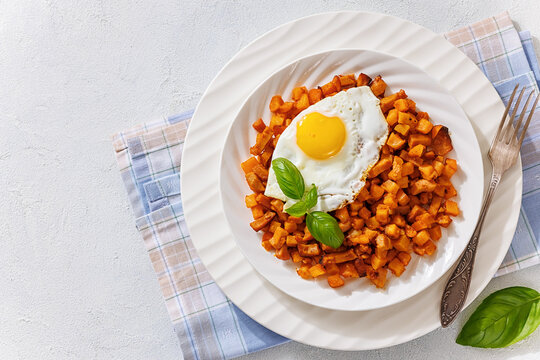Pan fried cubed potatoes and sausage on plate