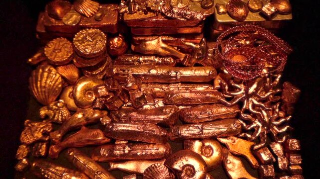 Zoom-in on golden treasure inside pirate treasure chest.