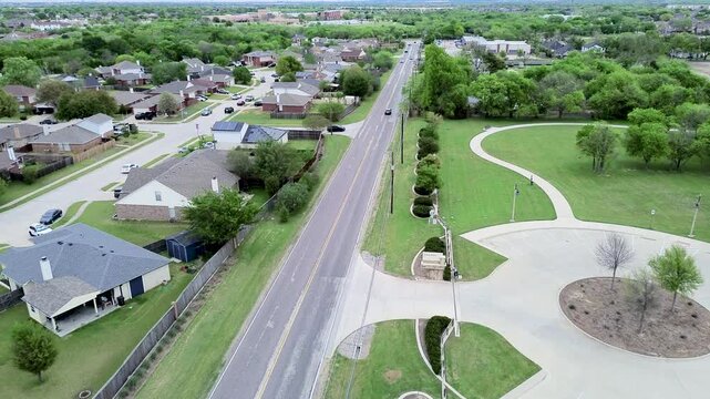 Circular concrete parking lot marks entrance to Eden Road Park off Mansfield Webb Road. Paved walking loops, manicured grass, landscaped median highlight civic design, Arlington, Texas