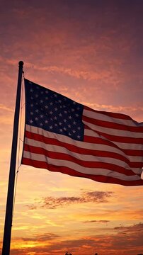 American Flag Waving at Vibrant Sunset - A low-angle shot captures the American flag gracefully waving against a backdrop of a vibrant, colorful sunset.