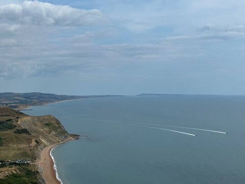 Jurassic Coast landscape with boats on the Atlantic Ocean seen from Golden Cap, Dorset, England, United Kingdom, July 2025