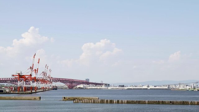 夏空の下に広がる大阪南港の湾岸風景と赤く大きい港大橋