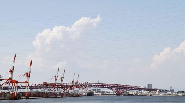 夏空の下に広がる大阪南港の湾岸風景と赤く大きい港大橋