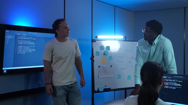 Diverse software developer team collaborating on computer code in modern IT office, Male programmers and female colleague brainstorming future technology business innovations and smart digital system