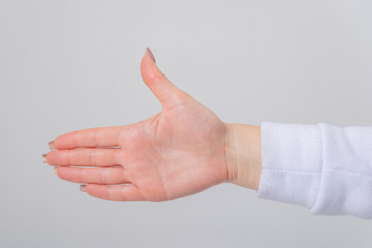 Person's hand extending, fingers together and thumb up, creating a playful gesture resembling a hand pistol, symbolizing communication, game, or direction