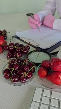 Comparison of strawberries and cherries on a lab desk with research activities and tools in a clean environment