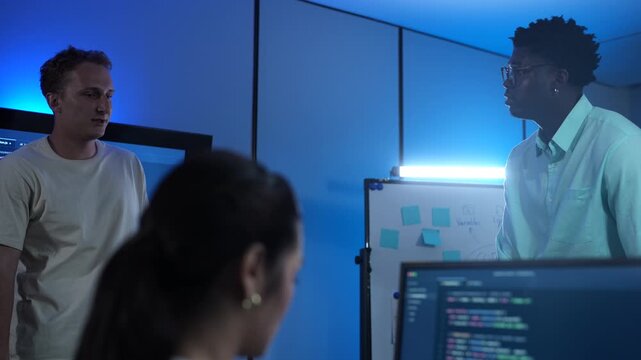 Diverse software developer team collaborating on computer code in modern IT office, Male programmers and female colleague brainstorming future technology business innovations and smart digital system