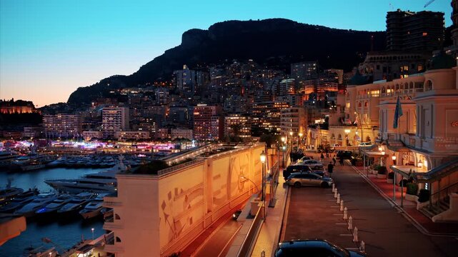 Night motion in monaco city skyline footage of monte carlo harbor with luxury yachts and architecture under twilight sky.