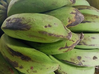 Close-up of unripe green banana fruit showing fungal disease, spot necrosis, and post-harvest spoilage symptoms in agriculture © alimin