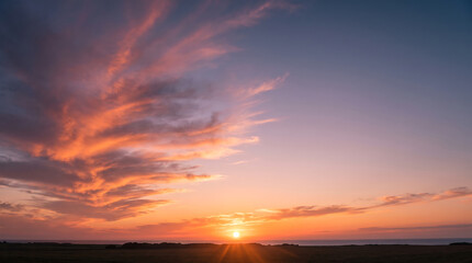Fototapeta premium Vibrant Sunset Sky with Radiant Orange and Pink Clouds over Horizon Landscape