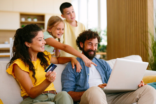 Parents and children enjoying a moment of connection while making online purchases on a laptop, representing modern family life, e-commerce, and digital convenience