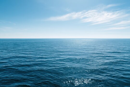 Azure ocean scene with gentle waves, crisp sky, and wispy clouds