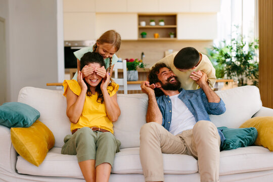 Parents laughing with children during playful family time at home