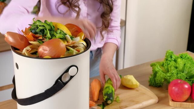 Woman preparing food scraps and adding them to compost bin for recycling and sustainability.