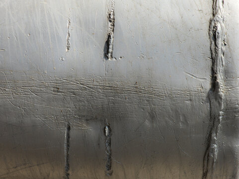 Close-up of Weathered Aluminum Metallic Surface with Scratches and Welds