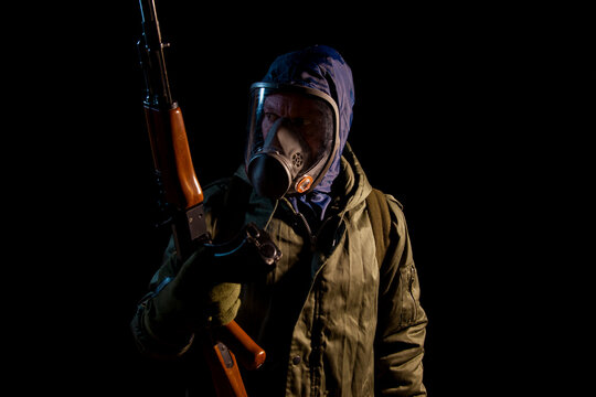 Hombre con mascara de gas y armado con un rifle sobre fondo negro