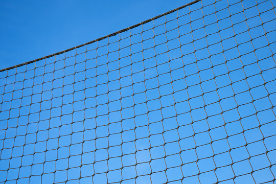 Net supported by a metal post used in outdoor sports courts.