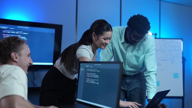 Diverse software developer team collaborating on computer code in modern IT office, Male programmers and female colleague brainstorming future technology business innovations and smart digital system