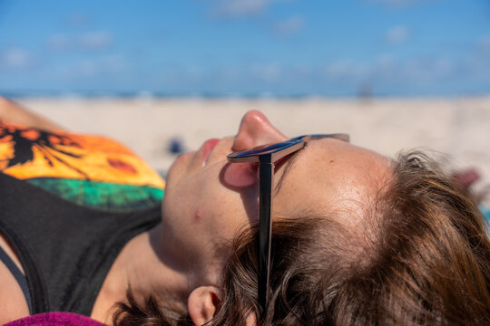 Woman Sunbathing On Beach In Sunglasses During Summer Vacation Relaxation And Coastal Leisure