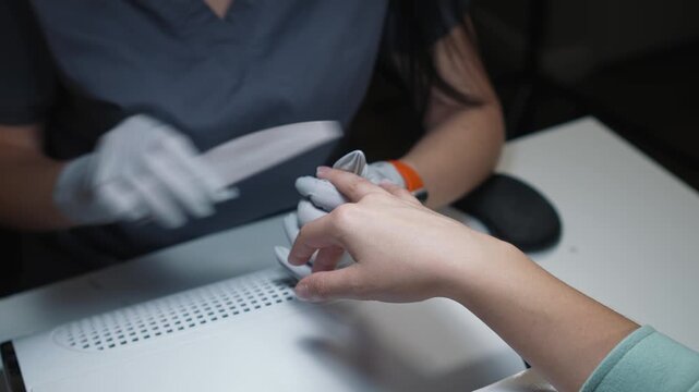 Nail treatment with file during manicure process in beauty salon as part of regular hand care