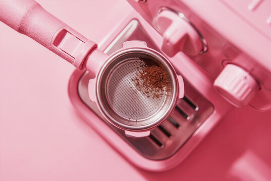 Espresso coffee grounds in a portafilter on a pink machine