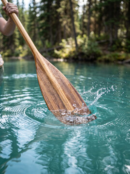 Paddling Wooden Oar In Splashing Turquoise Alpine Lake Water