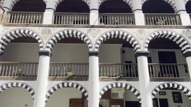 Arcaded galleries surround the inner courtyard of Rila Monastery, revealing rows of columns, arches and traditional monastic architecture at Bulgaria&rsquo;s iconic Orthodox sanctuary
