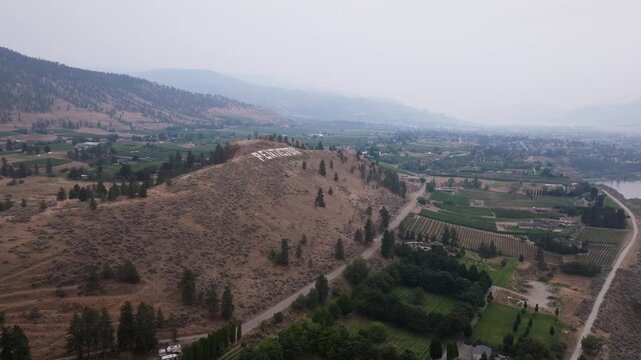 Smoke above an orchard rich area with town name written on a hill